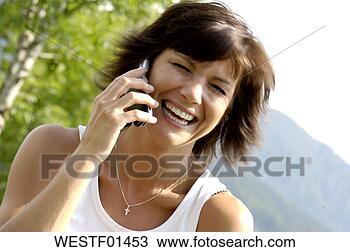 Banco de Imagem - mulher,  usando, 
 móvel,  telefone, 
 rir,  close-up. 
fotosearch - busca 
de fotos, imagens 
e clipart