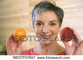 Picture - mature woman holding 
fruits, smiling, 
portrait. fotosearch 
- search stock 
photos, pictures, 
images, and photo 
clipart