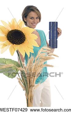 Stock Photograph - woman holding 
solar cells, sunflower 
in foreground. 
fotosearch - search 
stock photos, 
pictures, images, 
and photo clipart