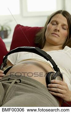 Banco de Imagem - mulher,  fones, 
 barriga,  sofá, 
 close-up. fotosearch 
- busca de fotos, 
imagens e clipart