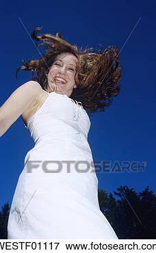 Foto - jovem,  mulher, 
 pular,  sorrindo, 
 baixo,  ângulo, 
 vista. fotosearch 
- busca de fotos, 
imagens e clipart
