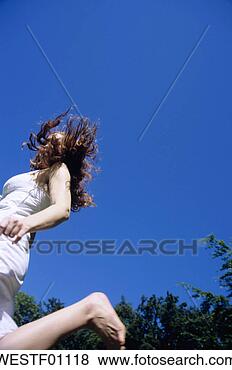 Banco de Imagem - jovem,  mulher, 
 pular,  sorrindo, 
 baixo,  ângulo, 
 vista. fotosearch 
- busca de fotos, 
imagens e clipart