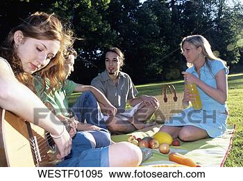 Banco de Imagem - jovem,  mulher, 
 tocando,  guitarra, 
 amigos,  jardim, 
 close-up. fotosearch 
- busca de fotos, 
imagens e clipart