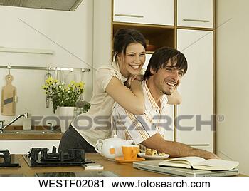 Arquivo de Fotografia - jovem,  par,  
cozinha,  olhar, 
 afastado,  sorrindo. 
fotosearch - busca 
de fotos, imagens 
e clipart