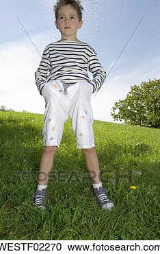 Stock Photography - boy (4-7) standing 
in park, hands 
in pockets, low 
angle view. fotosearch 
- search stock 
photos, pictures, 
images, and photo 
clipart