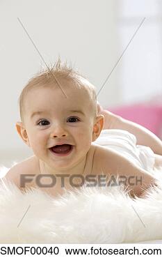 Stock Photography - baby boy (6-12 
months) lying 
on belly, smiling, 
portrait. fotosearch 
- search stock 
photos, pictures, 
images, and photo 
clipart