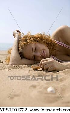 Banco de Imagem - jovem,  mulher, 
 mentindo,  areia, 
 tocando,  concha. 
fotosearch - busca 
de fotos, imagens 
e clipart