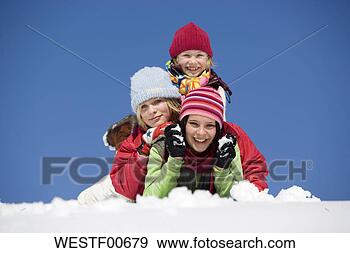 Stock Photograph - austria, girls 
(6-17) lying on 
snow, smiling, 
portrait. fotosearch 
- search stock 
photos, pictures, 
images, and photo 
clipart