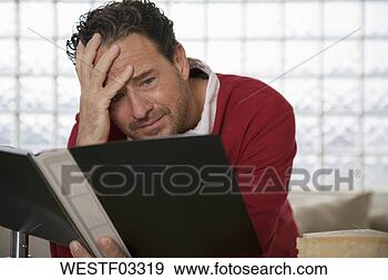 Stock Photograph - man holding school 
report, hand on 
head. fotosearch 
- search stock 
photos, pictures, 
images, and photo 
clipart