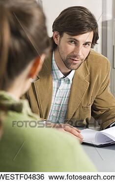 Stock Photo - business colleague 
discussing in 
office, focus 
on man in background. 
fotosearch - search 
stock photos, 
pictures, images, 
and photo clipart