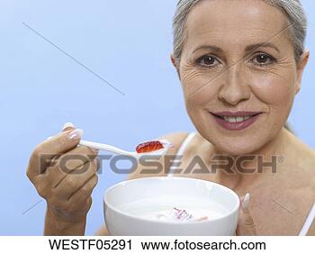 Arquivo de Fotografia - sênior,  mulher, 
 segurando,  tigela, 
 colher,  retrato. 
fotosearch - busca 
de fotos, imagens 
e clipart