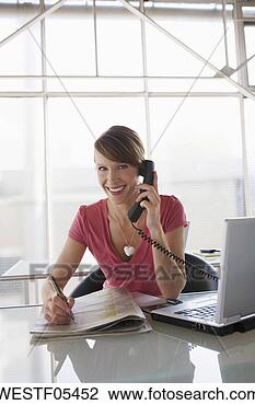 Banco de Imagem - mulher,  escrivaninha, 
 usando,  telefone. 
fotosearch - busca 
de fotos, imagens 
e clipart