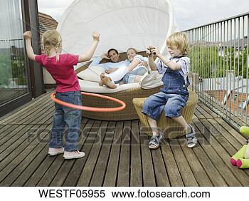 Stock Image - family on balcony, 
children playing. 
fotosearch - search 
stock photos, 
pictures, images, 
and photo clipart