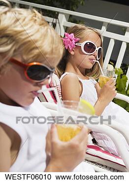 Arquivo de Fotografias - irmão,  irmã, 
 mentindo,  convés, 
 cadeiras,  bebendo, 
 suco. fotosearch 
- busca de fotos, 
imagens e clipart