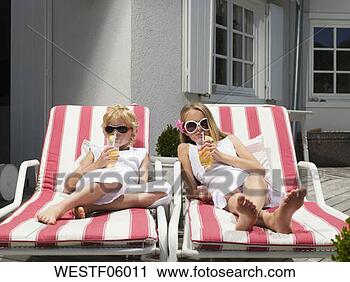 Arquivo de Fotografia - irmão,  irmã, 
 mentindo,  convés, 
 cadeiras,  bebendo, 
 suco. fotosearch 
- busca de fotos, 
imagens e clipart