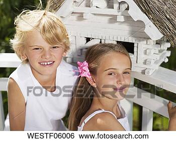Banco de Imagem - menina,  menino, 
 sentando,  frente, 
 birdhouse,  retrato. 
fotosearch - busca 
de fotos, imagens 
e clipart