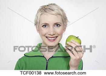 Banco de Imagem - jovem,  mulher, 
 segurando,  maçã, 
 retrato. fotosearch 
- busca de fotos, 
imagens e clipart