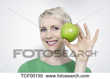 Banco de Imagem - jovem,  mulher, 
 segurando,  verde, 
 maçã,  retrato. 
fotosearch - busca 
de fotos, imagens 
e clipart