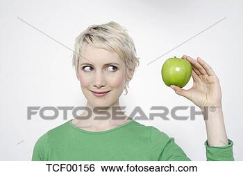 Banco de Imagem - jovem,  mulher, 
 segurando,  verde, 
 maçã,  retrato. 
fotosearch - busca 
de fotos, imagens 
e clipart