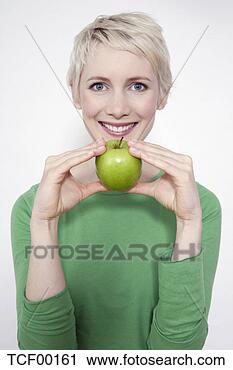 Arquivo de Fotografia - jovem,  mulher, 
 segurando,  verde, 
 maçã,  retrato. 
fotosearch - busca 
de fotos, imagens 
e clipart