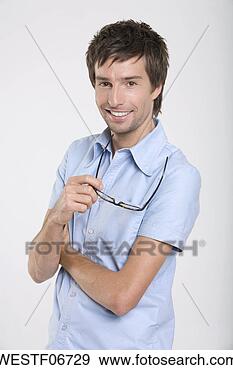 Arquivo Fotográficos - jovem,  segurando, 
 espetáculos, 
 sorrindo,  retrato. 
fotosearch - busca 
de fotos, imagens 
e clipart