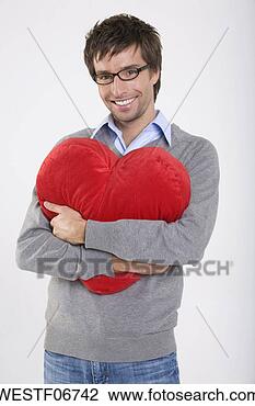 Banco de Imagem - jovem,  segurando, 
 heart-shaped, 
 almofada,  sorrindo, 
 retrato. fotosearch 
- busca de fotos, 
imagens e clipart