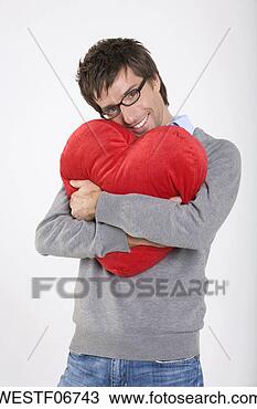 Banco de Imagem - jovem,  segurando, 
 heart-shaped, 
 almofada,  sorrindo, 
 retrato. fotosearch 
- busca de fotos, 
imagens e clipart