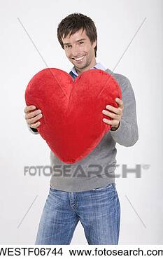 Banco de Imagem - jovem,  segurando, 
 heart-shaped, 
 almofada,  sorrindo, 
 retrato. fotosearch 
- busca de fotos, 
imagens e clipart