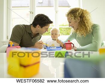 Banco de Imagem - jovem,  família, 
 pai,  alimentação, 
 bebê,  menino, 
 months). fotosearch 
- busca de fotos, 
imagens e clipart