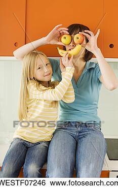 Stock Photo - mother and daughter 
(8-9) in the kitchen, 
 mother holding 
apples in. fotosearch 
- search stock 
photos, pictures, 
images, and photo 
clipart