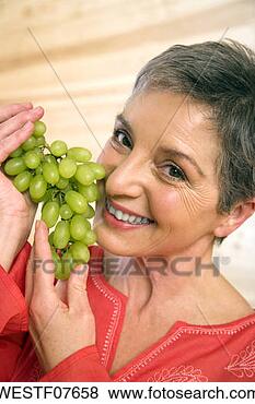 Banco de Imagem - maduras,  mulher, 
 segurando,  uvas, 
 sorrindo,  retrato, 
 close-up. fotosearch 
- busca de fotos, 
imagens e clipart