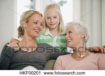 Stock Photography - girl (8-9) with 
mother and grandmother 
in living room, 
 smiling. fotosearch 
- search stock 
photos, pictures, 
images, and photo 
clipart