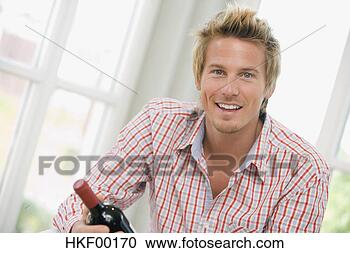 Arquivo de Fotografias - jovem,  segurando, 
 vinho,  garrafa, 
 sorrindo,  retrato. 
fotosearch - busca 
de fotos, imagens 
e clipart