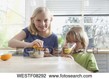 Stock Photo - boy and girl (8-9) 
preparing fresh 
orange juice, 
portrait. fotosearch 
- search stock 
photos, pictures, 
images, and photo 
clipart
