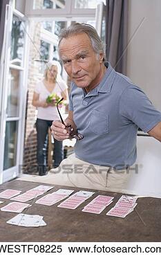 Stock Image - senior man playing 
solitaire,  senior 
woman standing 
in the doorway. 
fotosearch - search 
stock photos, 
pictures, images, 
and photo clipart
