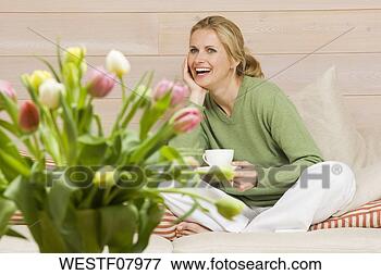 Picture - young woman holding 
cup of coffee, 
smiling, portrait. 
fotosearch - search 
stock photos, 
pictures, images, 
and photo clipart