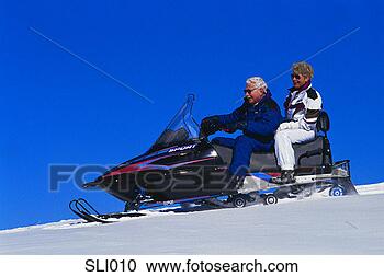 Stock Photography - older couple on 
snowmobile. fotosearch 
- search stock 
photos, pictures, 
images, and photo 
clipart