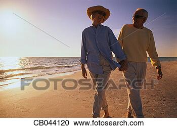 Stock Photography - older couple walking 
along beach. fotosearch 
- search stock 
photos, pictures, 
images, and photo 
clipart