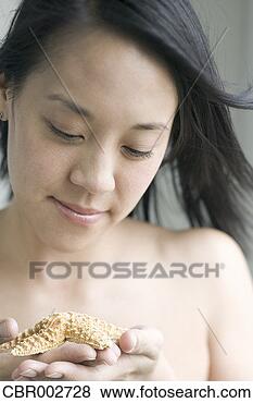 Stock Photo - young woman holding 
starfish. fotosearch 
- search stock 
photos, pictures, 
images, and photo 
clipart