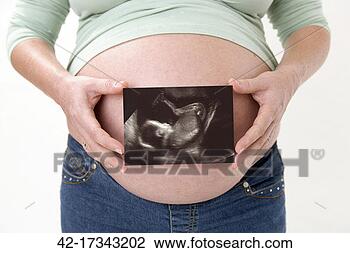 Stock Photo - pregnant woman 
holding ultrasound 
image. fotosearch 
- search stock 
photos, pictures, 
images, and photo 
clipart