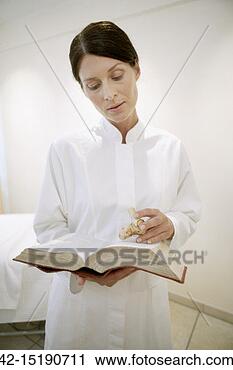 Stock Photography - doctor with ginseng 
referencing book. 
fotosearch - search 
stock photos, 
pictures, images, 
and photo clipart