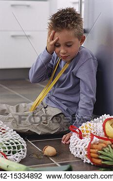 Stock Photo - boy sitting on 
floor in kitchen, 
looking at broken 
egg. fotosearch 
- search stock 
photos, pictures, 
images, and photo 
clipart