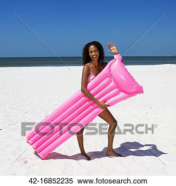 Banco de Imagem - jovem,  mulher, 
 waving,  segurando, 
 cor-de-rosa, 
 jangada. fotosearch 
- busca de fotos, 
imagens e clipart