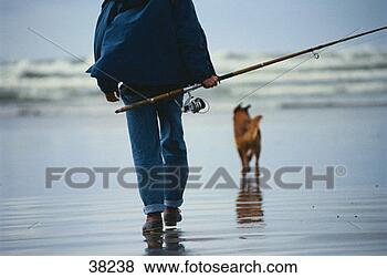 Stock Photo - man walking with 
dog carrying rod 
and reel. fotosearch 
- search stock 
photos, pictures, 
images, and photo 
clipart