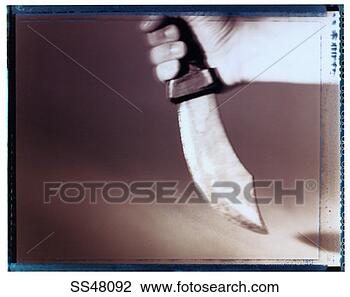 Stock Photo - man's hand holding 
a large knife. 
fotosearch - search 
stock photos, 
pictures, images, 
and photo clipart