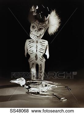 Stock Photo - skeleton figurine 
standing over 
a dead bird. fotosearch 
- search stock 
photos, pictures, 
images, and photo 
clipart