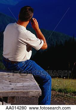 Stock Photography - man on a cellular 
phone sitting 
at a picnic table. 
fotosearch - search 
stock photos, 
pictures, images, 
and photo clipart