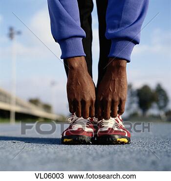 Stock Photo - male athlete stretching 
on track. fotosearch 
- search stock 
photos, pictures, 
images, and photo 
clipart