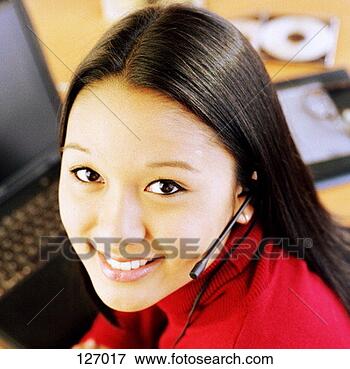 Picture - portrait of young 
asian woman with 
telephone headset. 
fotosearch - search 
stock photos, 
pictures, images, 
and photo clipart