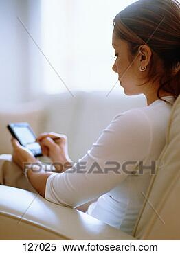 Stock Image - young woman using 
palm top. fotosearch 
- search stock 
photos, pictures, 
images, and photo 
clipart
